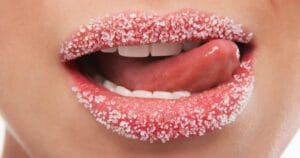 lips covered with sugar and a tongue licking the sugar